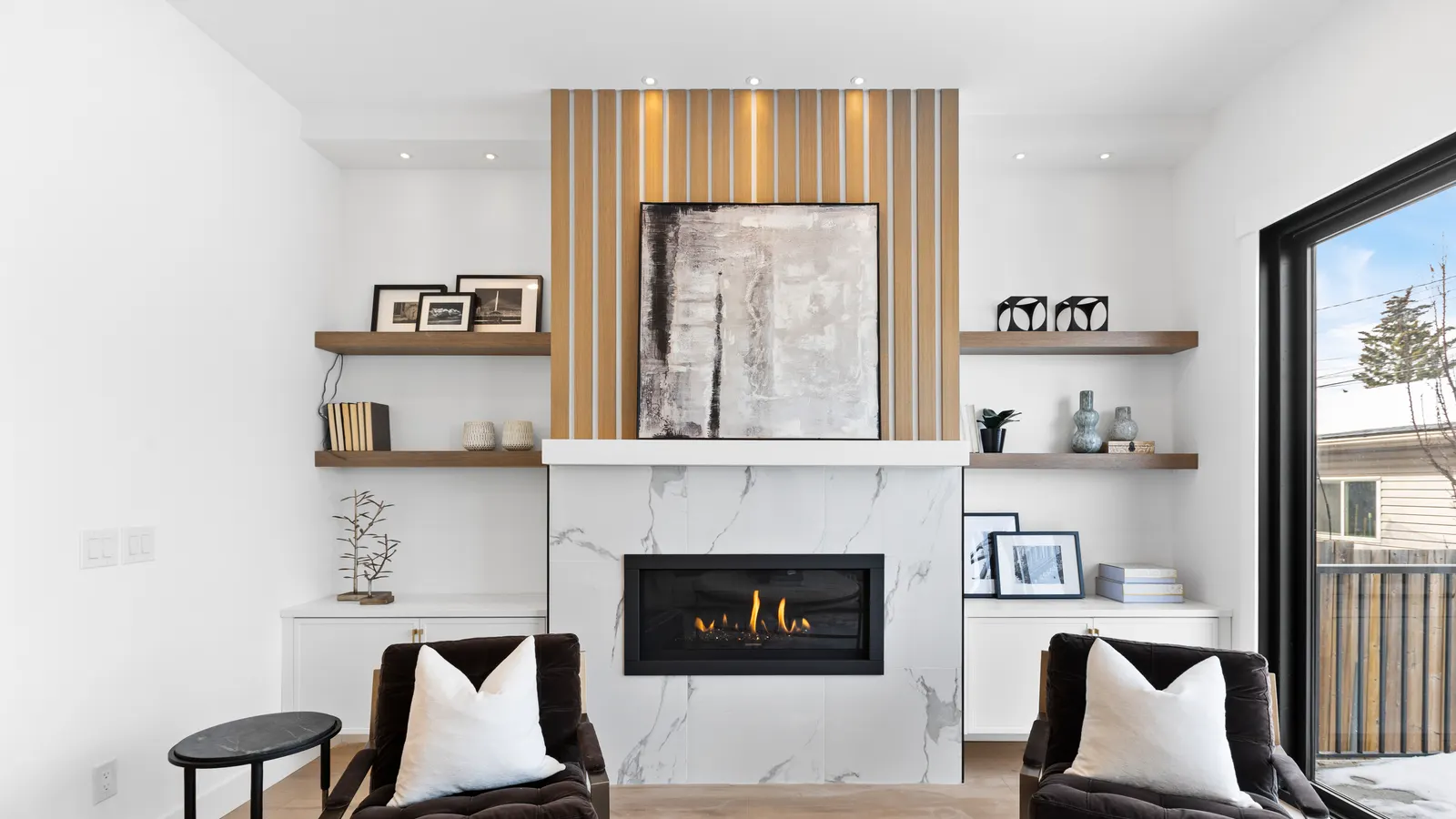 Naturally lit luxury Calgary living room with a marble fireplace feature wall and designer furnishings, an example of listing photography that sells