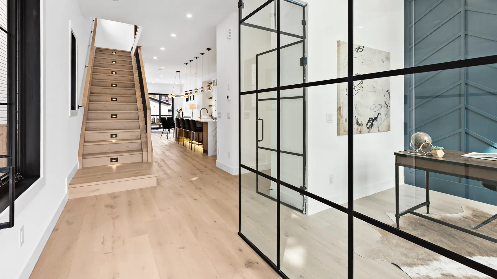 Architectural interior of a Calgary home with a staircase and glass-walled entry, representing precise spatial measurement to Alberta's RMS standard