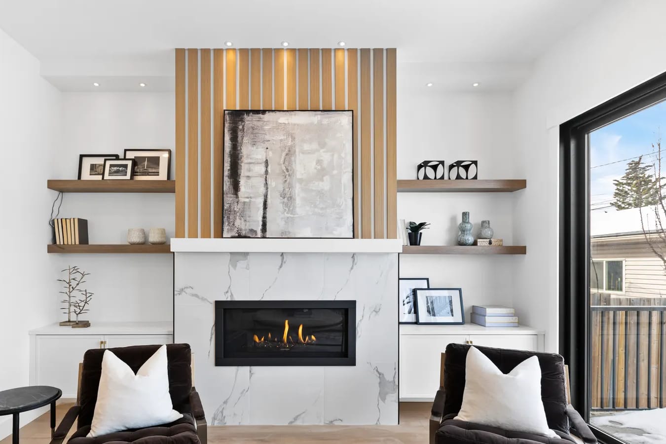 Naturally lit luxury Calgary living room with a marble fireplace feature wall and designer furnishings, an example of listing photography that sells